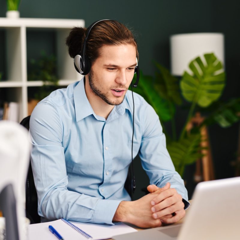 Young man working as customer support in the office